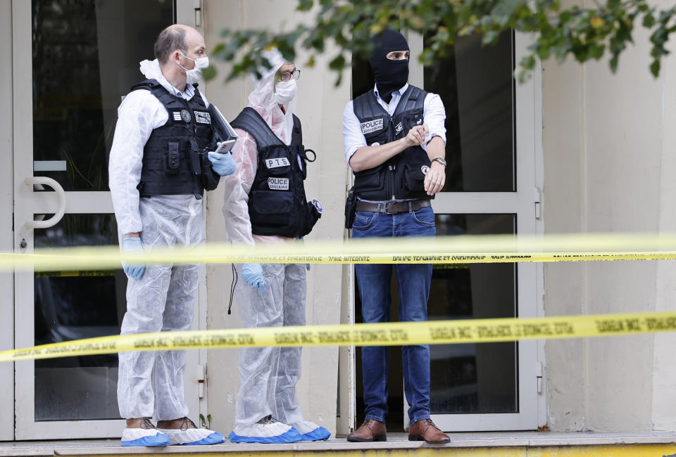 French investigating officers stand in front of the Gambetta high school in Arras, northeastern France, after a man armed with a knife killed a teacher and wounded another teacher and a security guard, an attack being investigated as potential terrorism, Friday Oct. 13, 2023. (Ludovic Marin, Pool via AP)