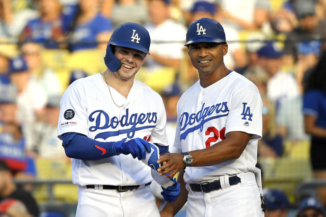 Los Angeles Dodgers' Gavin Lux, left, trips over Colorado Rockies