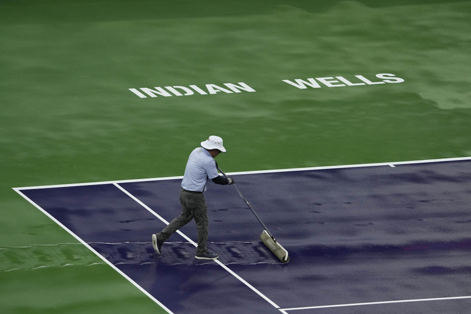 A worker dries off Stadium Court during a rain delay at the BNP Paribas Open tennis tournament Friday, March 10, 2023, in Indian Wells, Calif. (AP Photo/Mark J. Terrill)