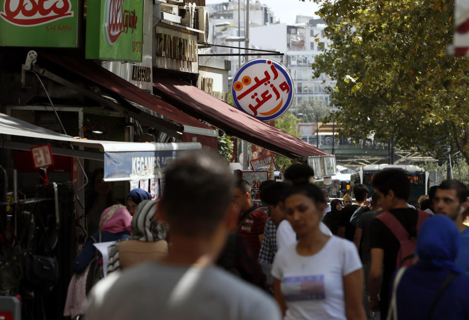 In this photo taken on Tuesday, Aug. 20, 2019, people walk past Syrian restaurants in the Istanbul neighborhood of Aksaray, where many Syrians live. Syrians say Turkey has been detaining and forcing some Syrian refugees to return back to their country the past month. The expulsions reflect increasing anti-refugee sentiment in Turkey, which opened its doors to millions of Syrians fleeing their country's civil war. (AP Photo/Lefteris Pitarakis)