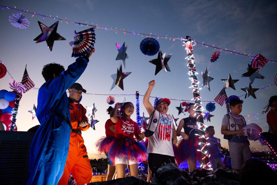Members of the Heart for the World Church dance on their float during the Electric Light Parade on Monday, July 3, 2023, at Apodaca Park. 