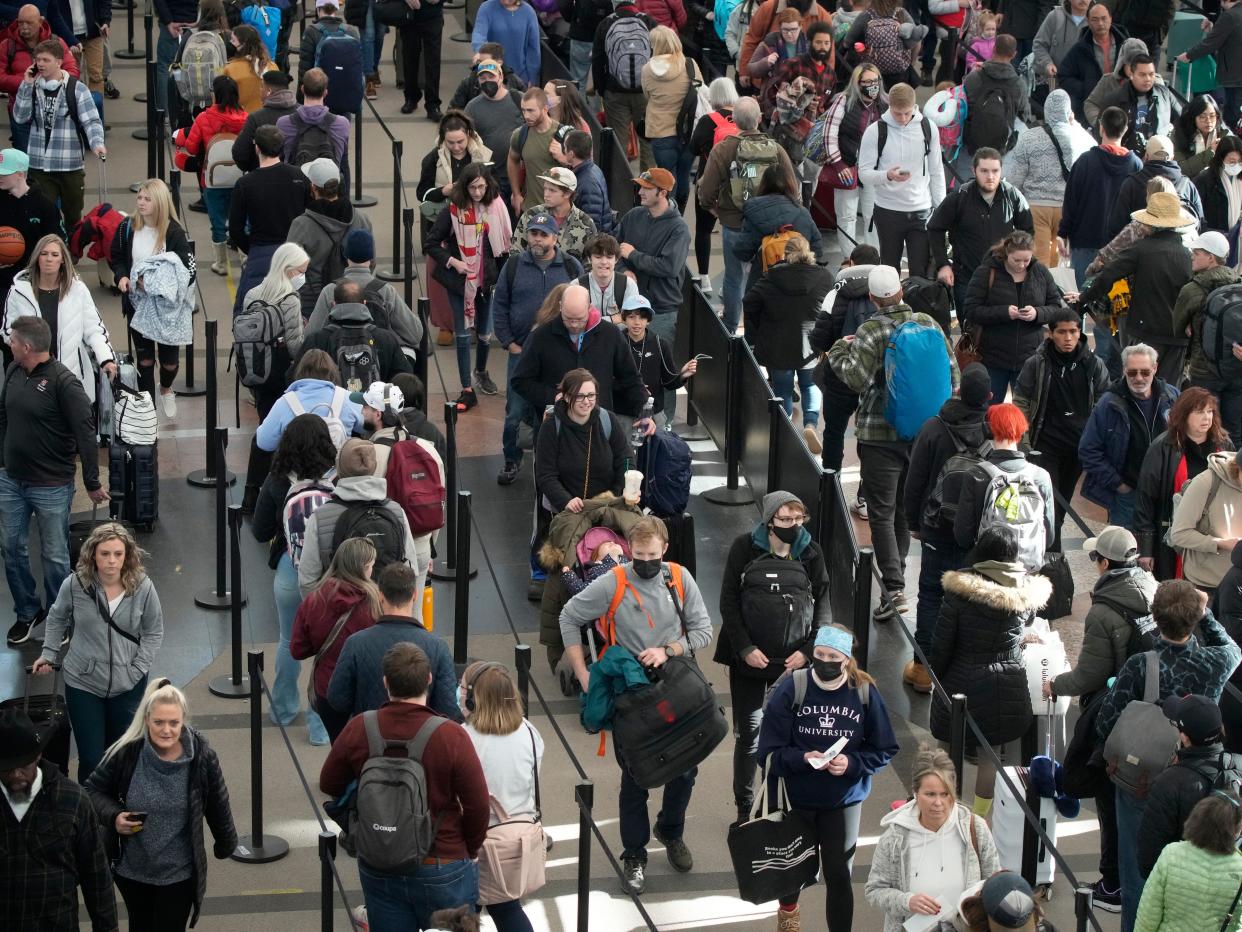 Travelers queue up to pass through the south security checkpoint in Denver International Airport after a winter storm swept over the country packing snow combined with Arctic cold, which created chaos for people trying to reach their destinations before the Christmas holiday, Friday, Dec. 23, 2022, in Denver.