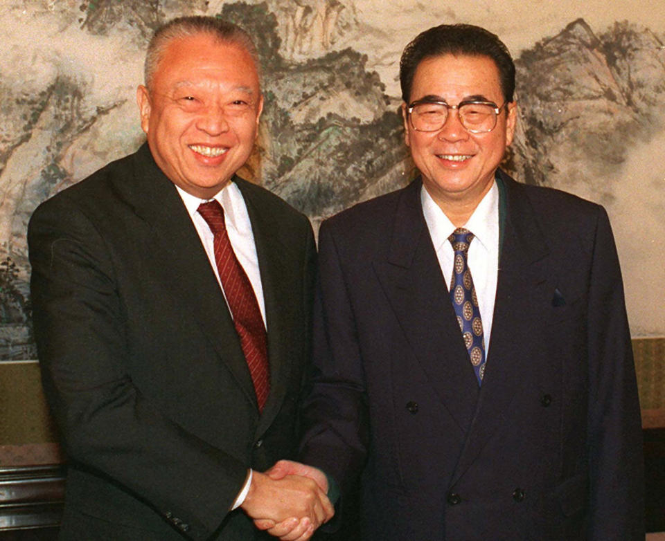 CORRECTS AGE TO 90, INSTEAD OF 91 - FILE - In this Dec. 10, 1997, file photo released by CHina's Xinhua News Agency, then Hong Kong leader Tung Chee-hwa and then Chinese Premier Li Peng shake hands at the start of their meeting in Beijing. Li Peng, a former hard-line Chinese premier best known for announcing martial law during the 1989 Tiananmen Square pro-democracy protests, has died. He was 90. (Xinhua via AP, File)