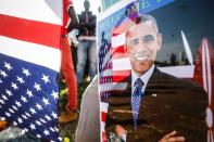 <p>A supporter of former US president Barack Obama wears a laminated badge featuring Obama, as he stands with others on the street and waits for Obama’s arrival prior to an opening ceremony of the Sauti Kuu Sports, Vocational and Training Centre in his ancestral home Kogelo, some 400km west of the capital Nairobi, Kenya on 16, July 2018. (Photo: Dai Kurokawa/EPA-EFE/REX/Shutterstock) </p>