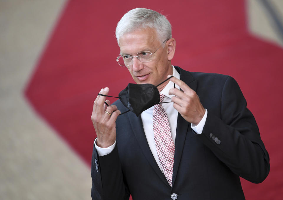 Latvian Prime Minister Krisjanis Karins removes his protective face mask as he arrives for an EU summit at the European Council building in Brussels, Thursday, June 24, 2021. At their summit in Brussels, EU leaders are set to take stock of coronavirus recovery plans, study ways to improve relations with Russia and Turkey, and insist on the need to develop migration partners with the countries of northern Africa, but a heated exchange over a new LGBT bill in Hungary is also likely. (John Thys, Pool Photo via AP)