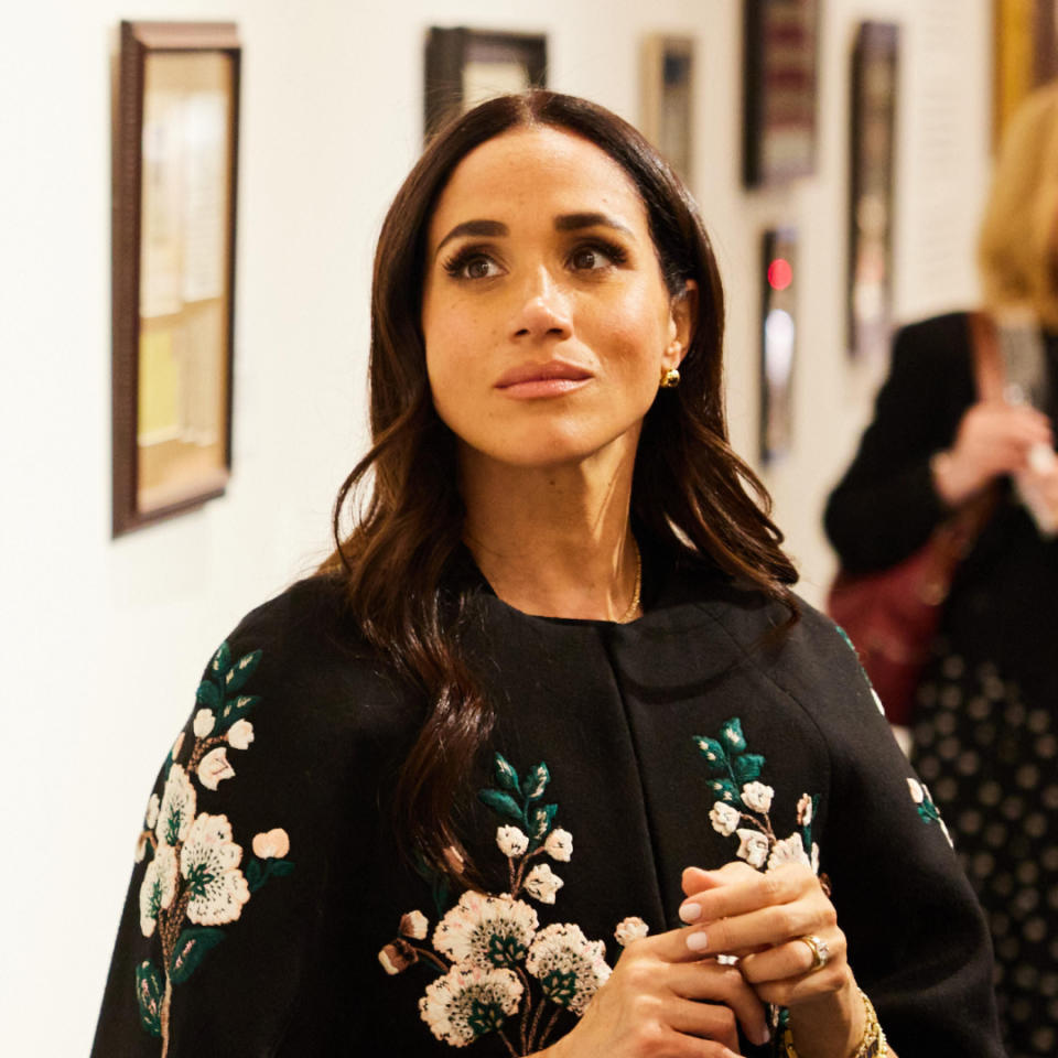 Meghan Markle wears a floral embroidered cape at an event