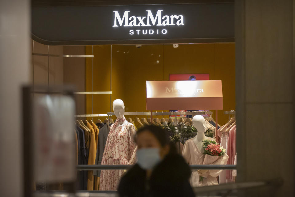 A shopper walks past a MaxMara clothing store at an upscale shopping mall in Beijing, Tuesday, March 16, 2021. Chinese state TV has criticized bathroom fixtures brand Kohler, automaker BMW and MaxMara fashion boutiques for using facial recognition to identify customers in a possible violation of privacy rules that took effect this year. (AP Photo/Mark Schiefelbein)