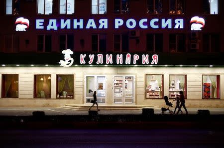 People walk past a sign reading "United Russia" on a building in central Stavropol, Russia, September 18, 2016. REUTERS/Eduard Korniyenko