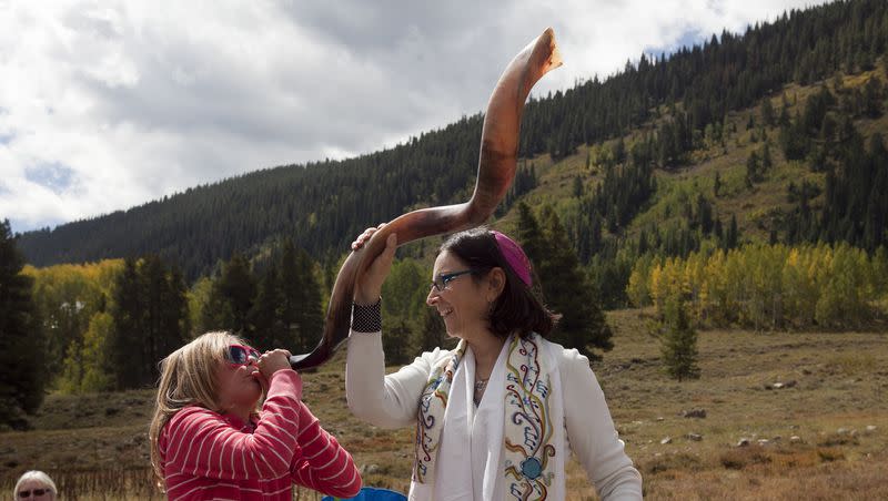 Lena Weisman, 10, left, of Crested Butte, Colo., blows a shofar with the help of Cantor Robbi Sherwin during Rosh Hashana services in the mountains of Crested Butte, Colo., on Thursday, Sept. 9, 2010.