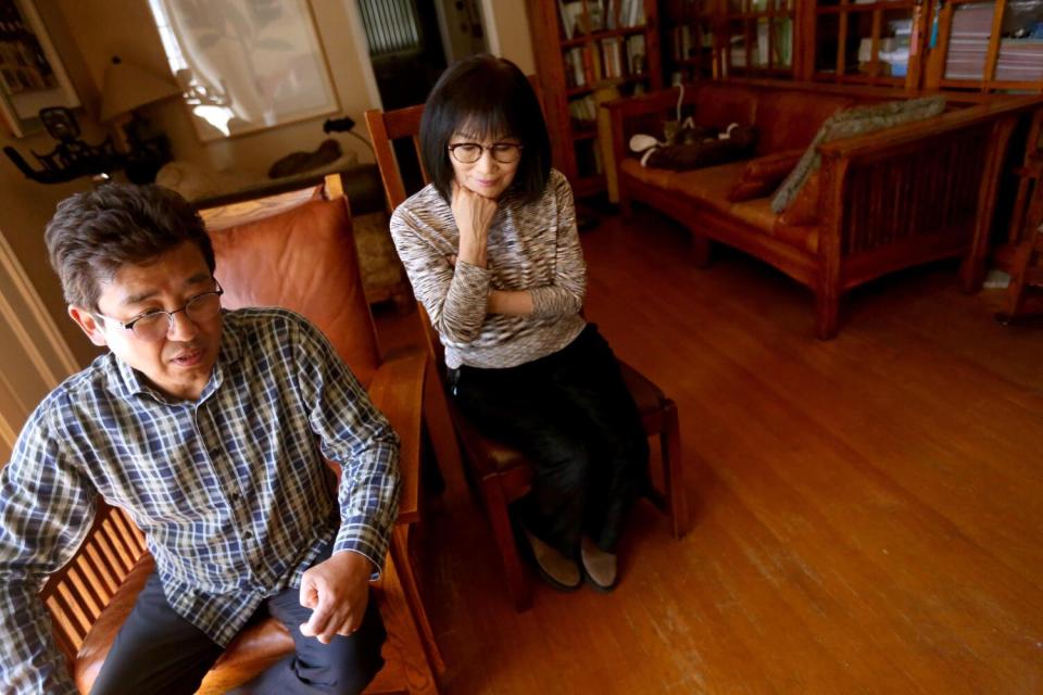 A man and a woman seated inside a home