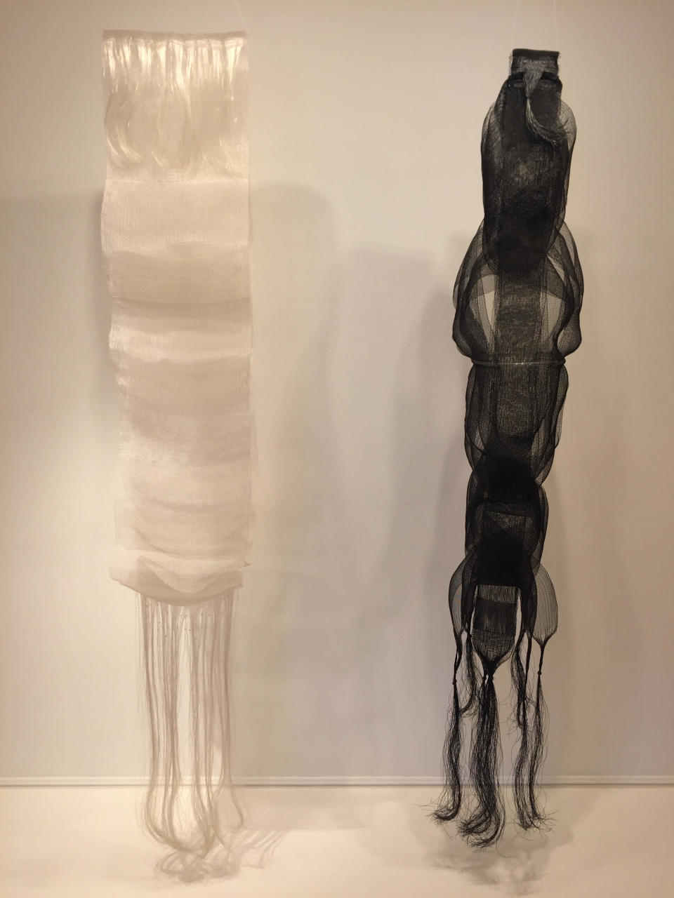 This photo taken on Dec. 2, 2016 shows nylon monofilament woven wall hangings "Ogawa II" (1969 - white) and "Nagare I" (1967 - black) by Berkeley, Calif., based 90-year-old fiber artist and weaver Kay Sekimachi. The pieces are part of the "Kay Sekimachi: Simple Complexity" exhibit the Craft and Folk Art Museum in Los Angeles, chronicling Sekimachi's decades-long career. The exhibit opened on Sept. 25, 2016, and runs through Jan. 8, 2017. (Solvej Schou via AP)