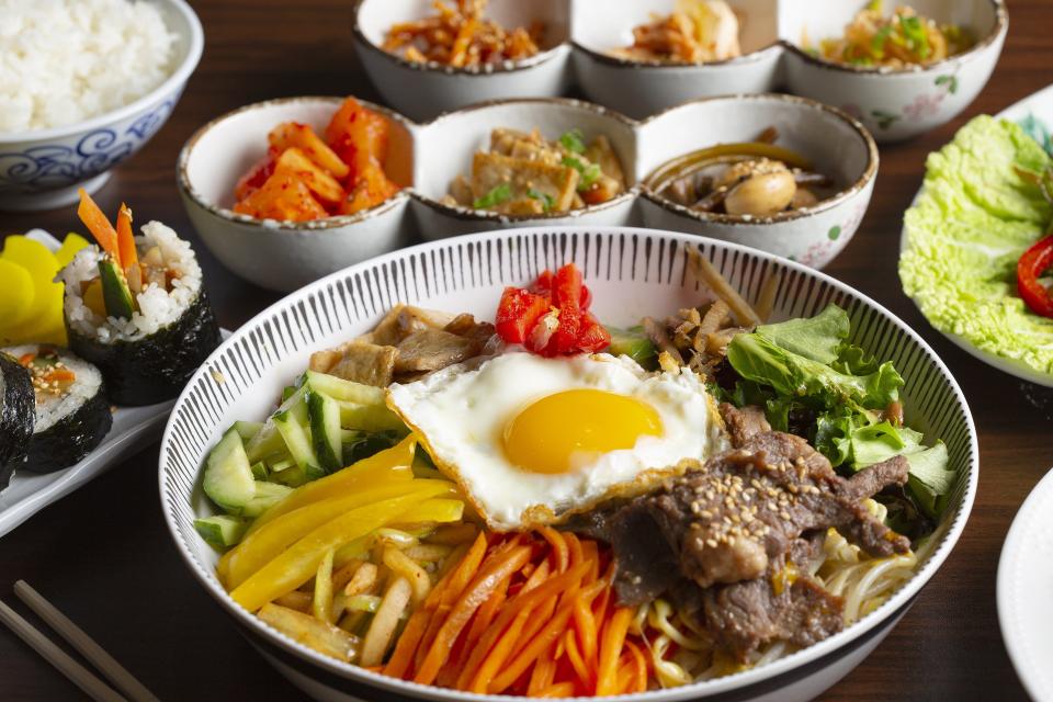 Bibimbap (center) served with kimchi on the side.