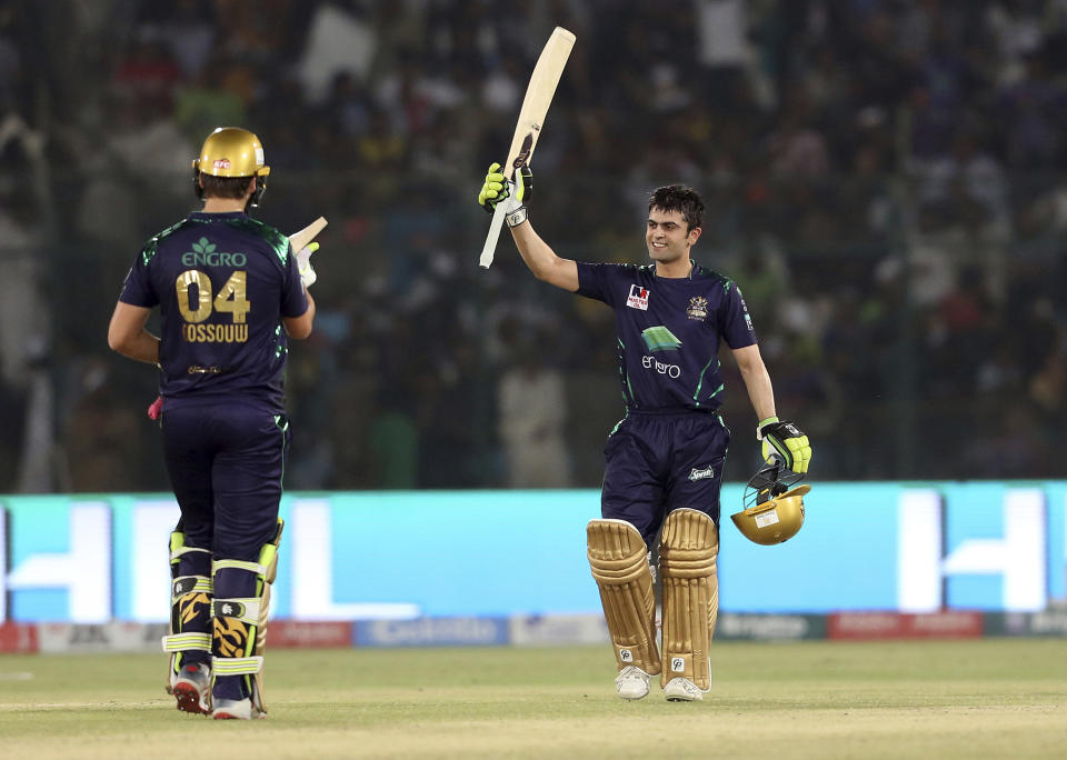 Quetta Gladiator batsman Ahmed Shahzad, right, raises his bat after completing fifty runs during the final cricket match of Pakistan Super League against Peshawar Zalmi at National stadium in Karachi, Pakistan, Sunday, March 17, 2019. (AP Photo/Fareed Khan)