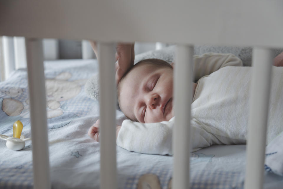 A baby sleeping in her crib