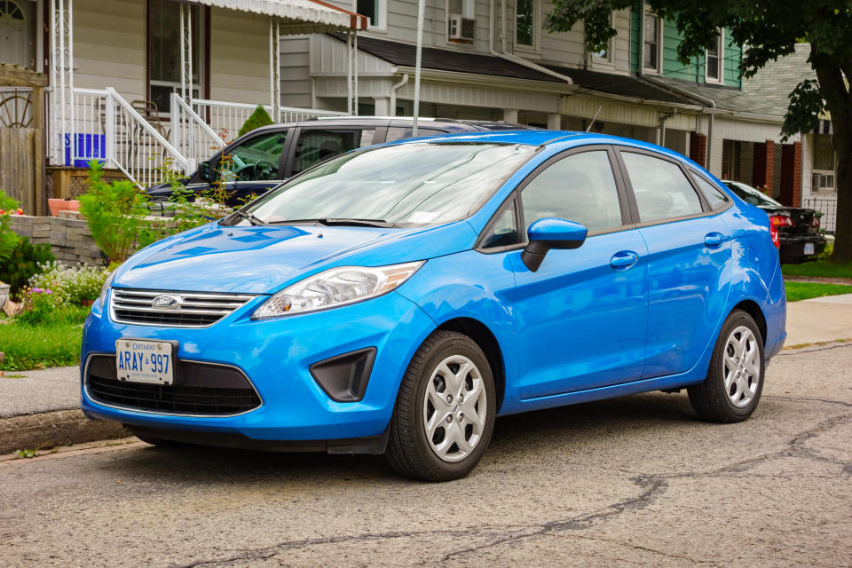 Hamilton, Canada - September 15, 2013: A blue colored Ford Fiesta compact sedan parked on a street in a residential area.