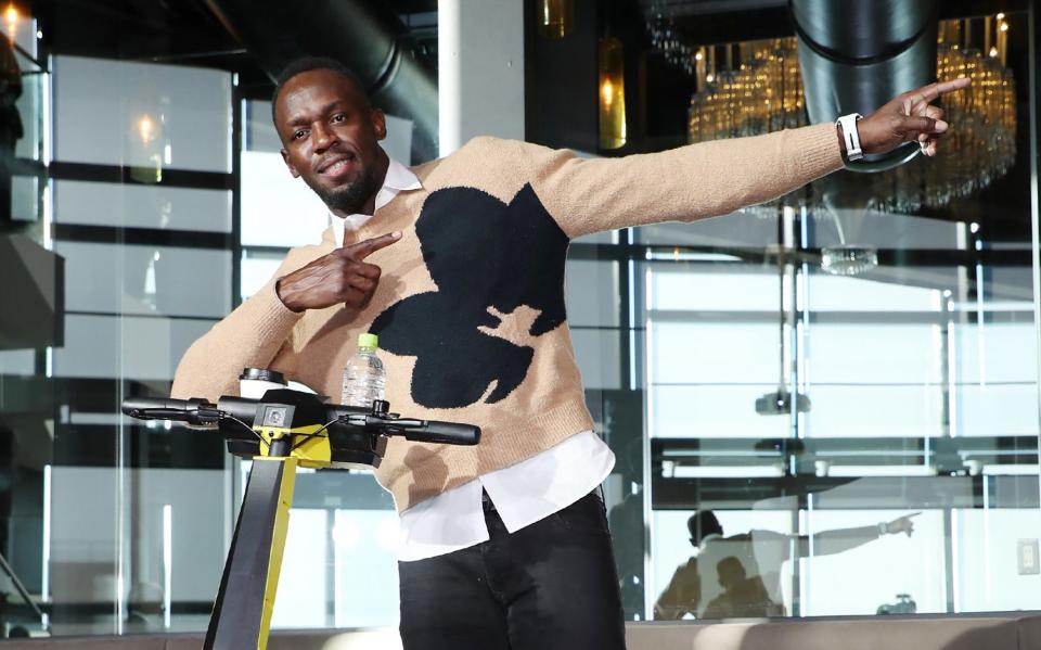 Jamaican Olympic sprinter Usain Bolt poses with a personal electric scooter from his new company Bolt - AFP