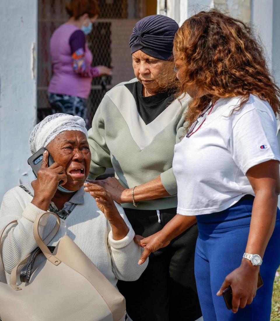 Francilia Jean is comforted as a fire engulfs her two-story apartment building at 395 NW 177th St. on Saturday, Jan. 28, 2023.