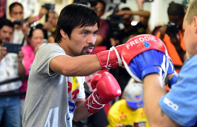 Boxer Manny Pacquiao spars with his coach Freddy Roach during a training session at the Wild Card Boxing Club in Hollywood, California on April 15, 2015