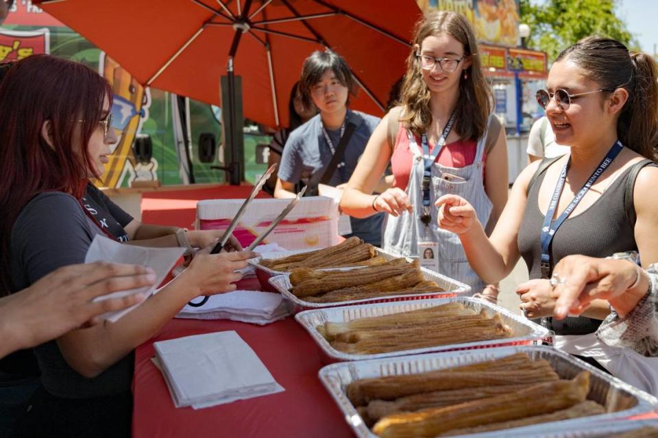 Sacramento Bee intern Angela Rodriguez orders a churro from Mely’s Churros during media day at the California State Fair Wednesday, July 12, 2023, in Sacramento.