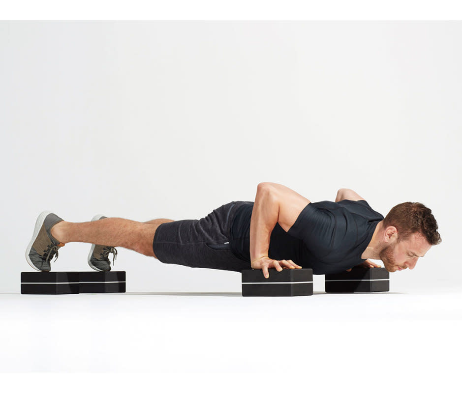 How to do it:<ol><li>Situate four yoga blocks or small plyo boxes under hands and feet, with hands wider than traditional pushup position.</li><li>Drop chest below hand level while maintaining a straight back, then press back up into plank position. As you get stronger, bring blocks under feet slightly closer together.</li></ol>