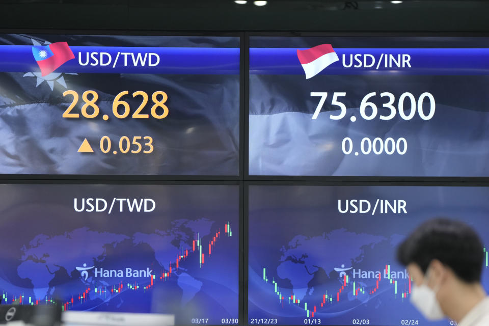 A currency trader stands near screens showing the foreign exchange rates at a foreign exchange dealing room in Seoul, South Korea, Wednesday, March 30, 2022. Asian stock markets followed Wall Street higher on Wednesday as talks on ending Russia's war on Ukraine appeared to make progress. (AP Photo/Lee Jin-man)