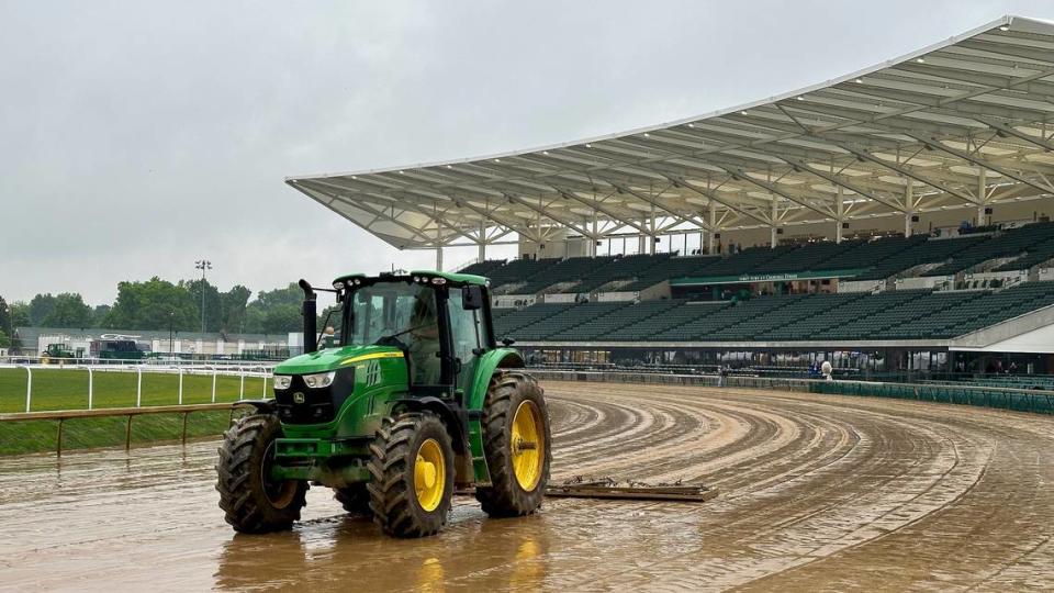 A tractor clears a muddy track as rain comes down during Kentucky Oaks Day on Friday at Churchill Downs. A chance of rain is in the forecast for Kentucky Derby Day on Saturday.