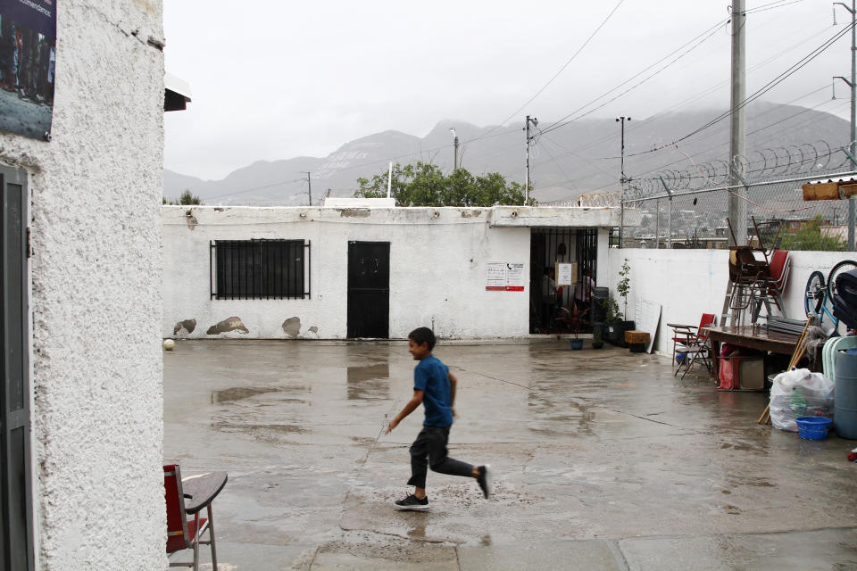 In this June 10, 2019, photo, Francisco Javier, 10, from El Salvador runs through light rain at the Buen Pastor migrant shelter in Ciudad Juarez, Mexico. His family was returned to Mexico after applying for asylum in the U.S. (AP Photo/Cedar Attanasio)