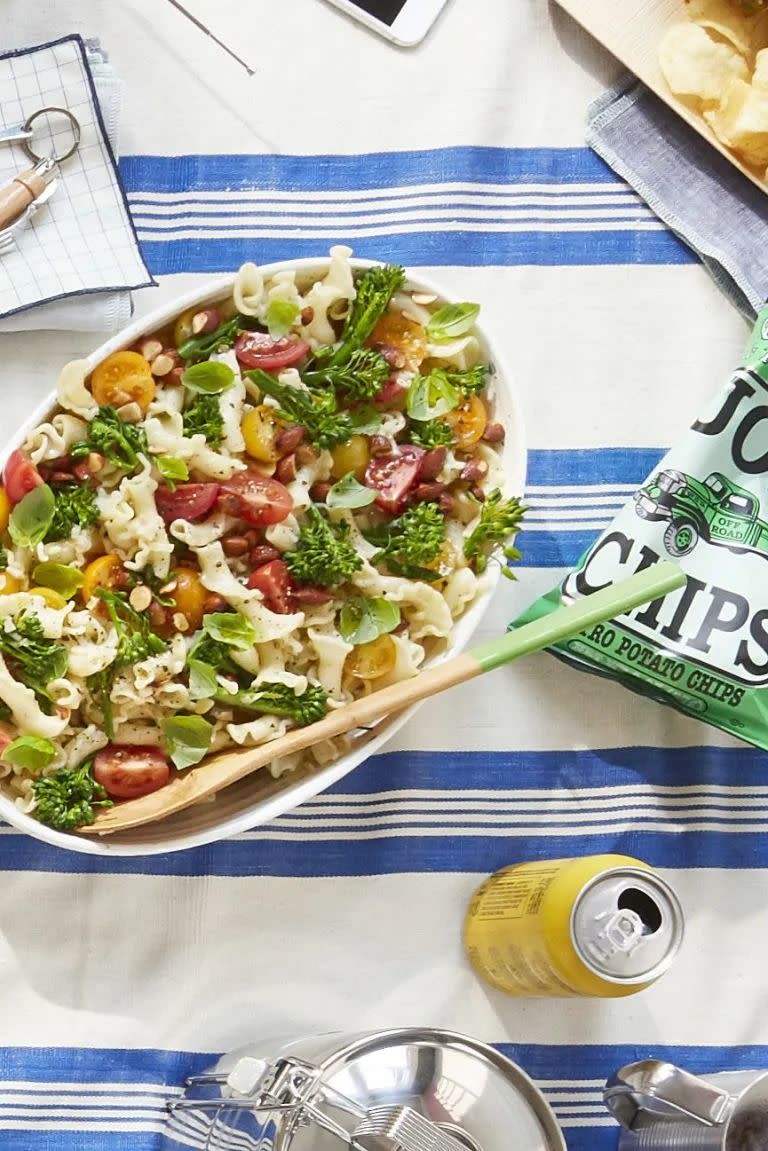 broccolini pasta salad in a serving bowl on a picnic blanket