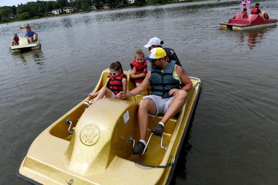 John and Carrie Thompson of Perry Township take a pedal boat out for a spin with daughters Lillian, 7, and Millie, 3, during Summerfest at Sippo Lake Park.