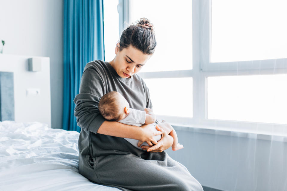 Pretty woman holding a sleeping newborn baby in her arms