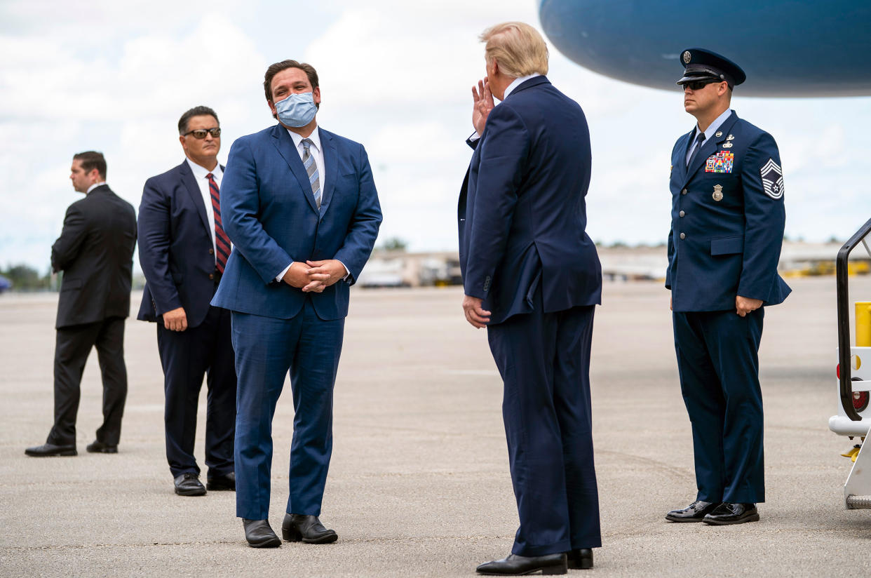 President Donald Trump is greeted by Gov. Ron DeSantis of Florida upon his arrival at Palm Beach International Airport