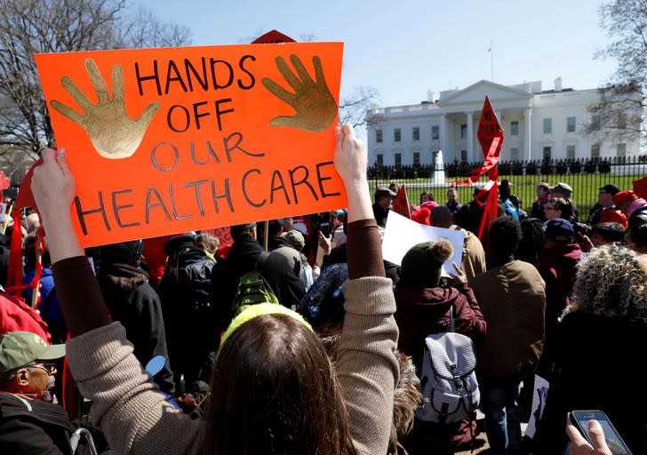 FILE PHOTO: Protesters demonstrate against U.S. President Donald Trump and his plans to end Obamacare outside the White House in Washington, U.S., March 23, 2017. REUTERS/Kevin Lamarque/File Photo 