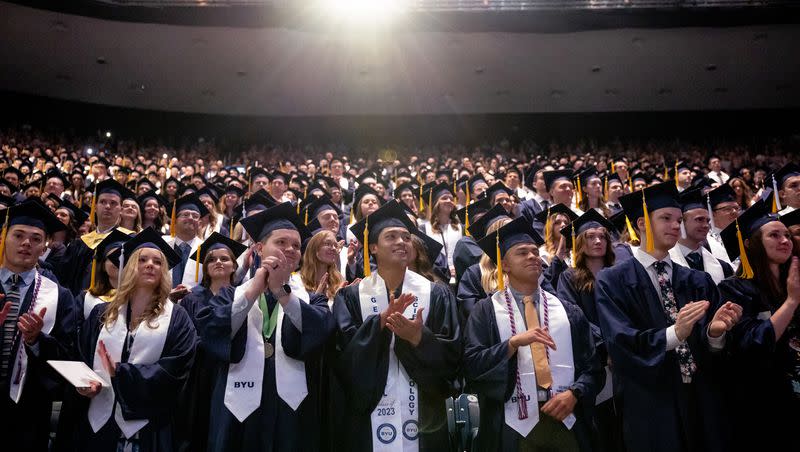 Brigham Young University students stand during the conferring of degrees during the university’s commencement at the Marriott Center in Provo on April 27, 2023.