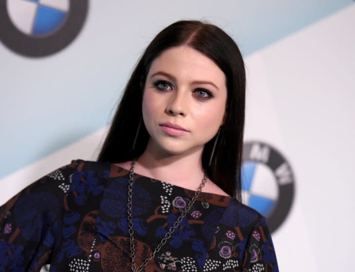 Michelle Trachtenberg poses in a patterned dress and dark eye makeup