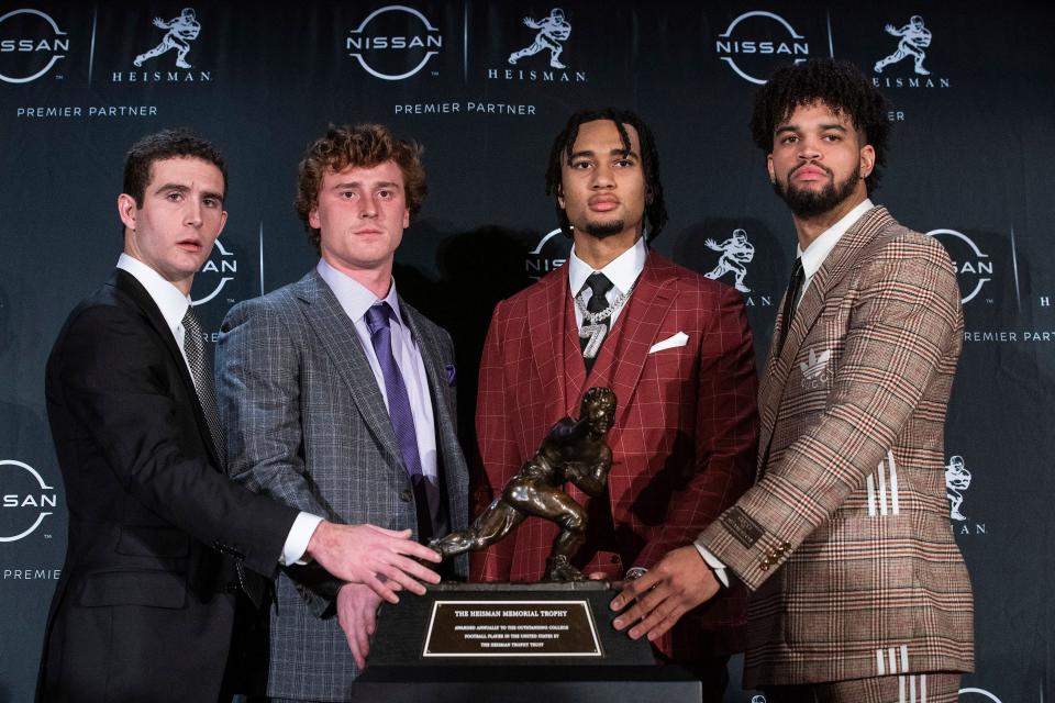 The Heisman trophy finalists, Georgia quarterback Stetson Bennett, TCU quarterback Max Duggan, Ohio State quarterback C.J. Stroud and Southern California quarterback Caleb Williams, pose with the trophy.