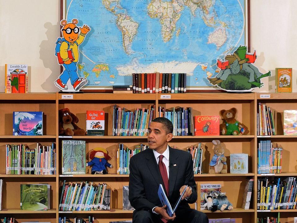 obama reads a childrens' book in a library