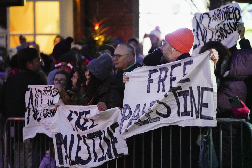 Pro-Palestinian protesters hold signs as President Joe Biden attends the annual Christmas Tree Lighting ceremony in Nantucket, Mass., Friday, Nov. 24, 2023. (AP Photo/Stephanie Scarbrough)