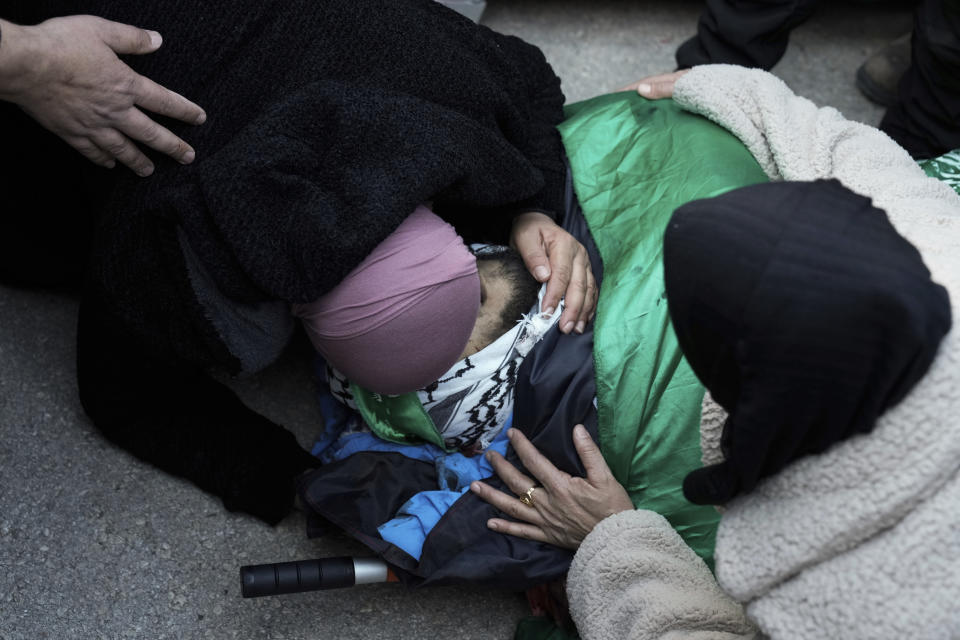 Mourners react over the bodies of six Palestinians, draped in the Hamas flags during their funeral in the West Bank city of Jenin on Sunday, Jan. 7, 2024. Six Palestinians and a member of Israel's paramilitary border police were killed in confrontations in a hot spot of violence in the Israeli-occupied West Bank, the Palestinian Health Ministry and the Israeli military said Sunday. (AP Photo/Majdi Mohammed)