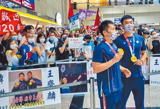 帶著台灣首面羽球金牌回國的「黃金男雙」組合王齊麟（右）、李洋（左）在4日光榮返台，李洋爸媽（後前排左一和左四）也到機場接機。（陳麒全攝）