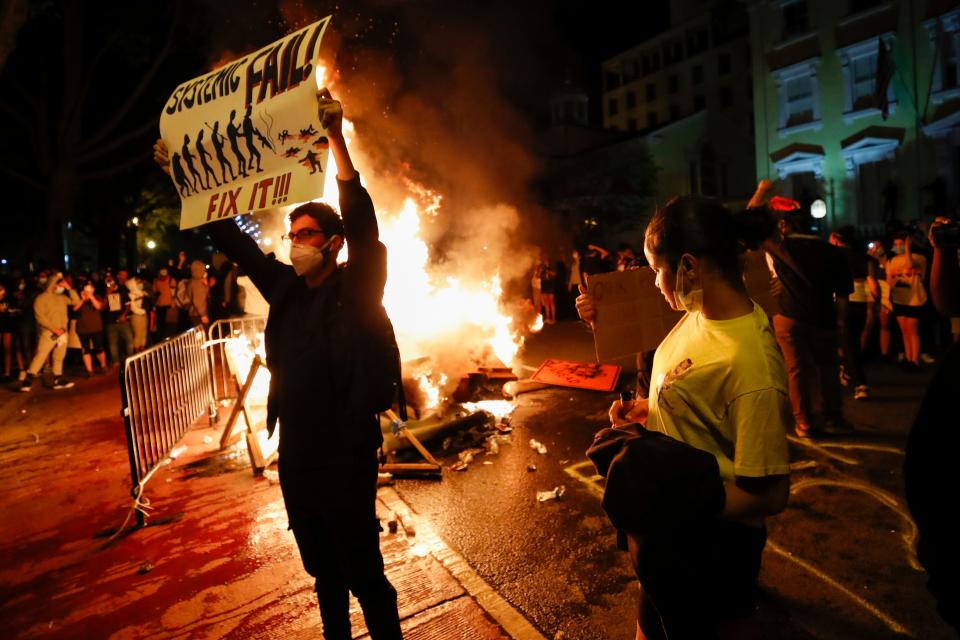 Demonstrators protest the death of George Floyd, Sunday, May 31, 2020, near the White House in Washington. Floyd died after being restrained by Minneapolis police officers.