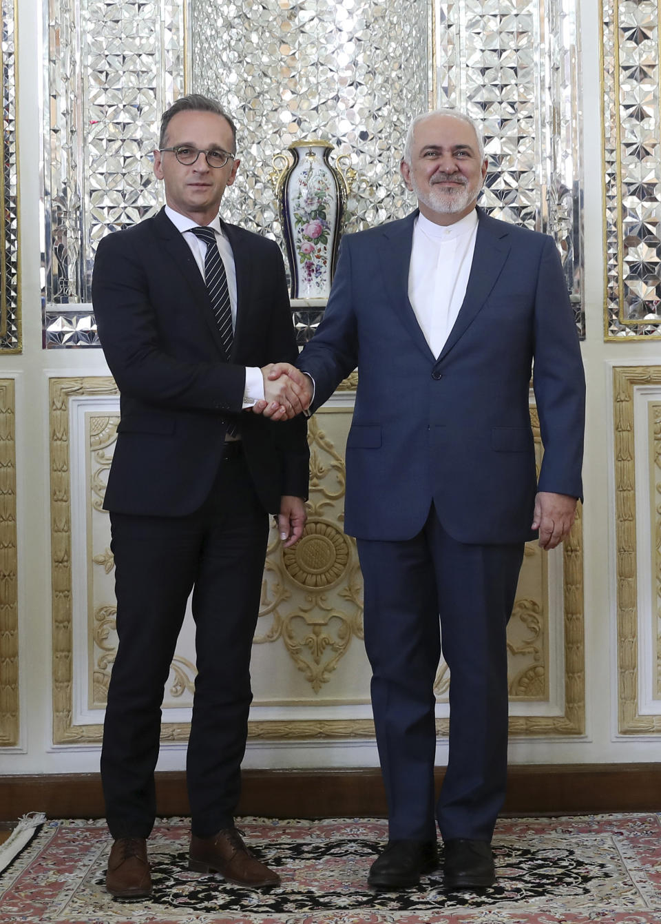 Iranian Foreign Minister Mohammad Javad Zarif, right, and his German counterpart Heiko Maas shake hands for the media prior to their meeting, in Tehran, Iran, Monday June 10, 2019. (AP Photo/Ebrahim Noroozi)