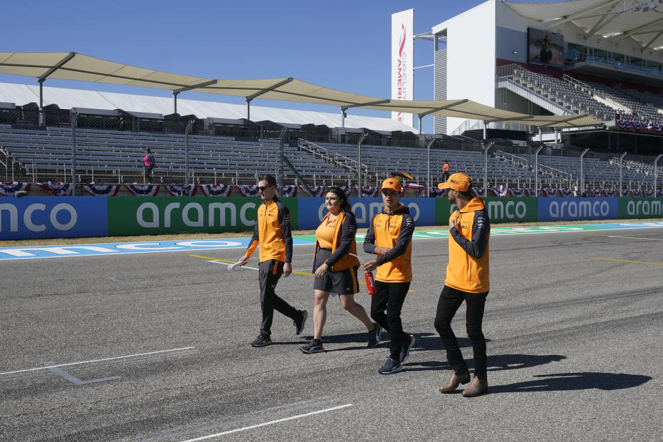 McLaren driver Daniel Ricciardo, right, of Australia, walks the track with his team before the Formula One U.S. Grand Prix auto race at the Circuit of the Americas, Thursday, Oct. 20, 2022, in Austin, Texas. (AP Photo/Darron Cummings)