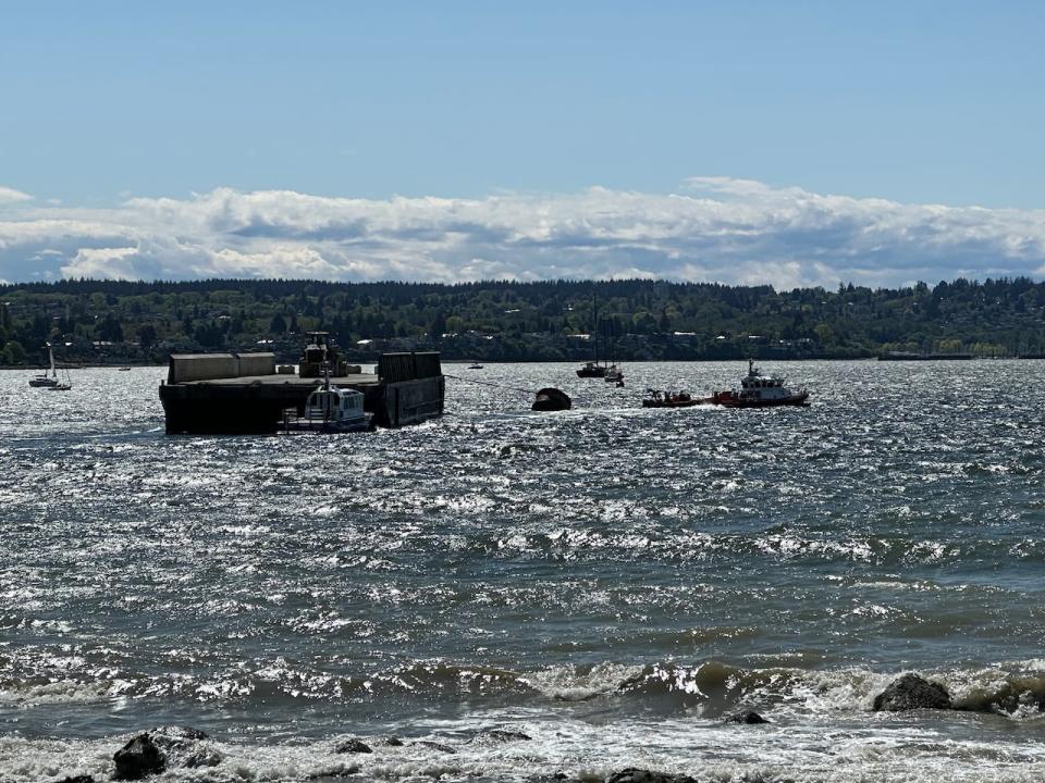 The barge appeared to be carrying a vehicle when it was being towed away by the coast guard and commercial tugboats.