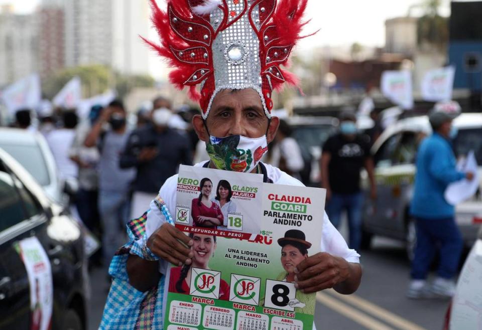 Wearing a mask to curb the spread of the new coronavirus, a supporter of Presidential candidate Veronika Mendoza of the Together for Peru party holds a calendar sporting her photo during a campaign stop in Lima, Peru, Tuesday, April 6, 2021. Peru’s general election is set for April 11.