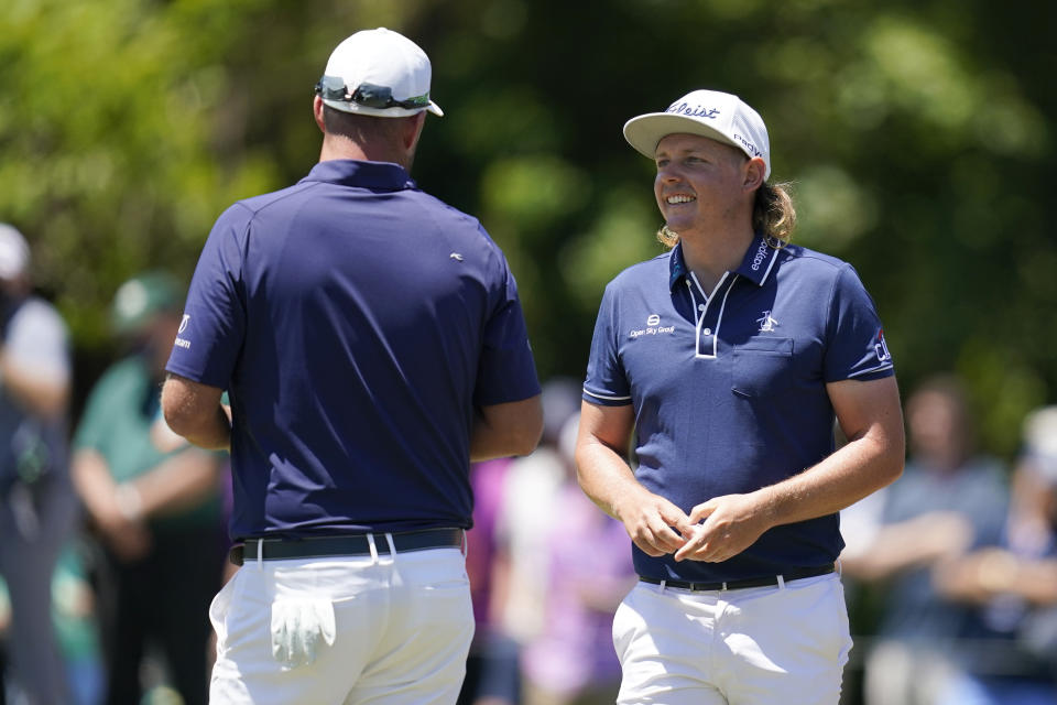 Cameron Smith, of Australia, talks with his teammate Marc Leishman, of Australia, left, after making his putt on the first green during the final round of the PGA Zurich Classic golf tournament at TPC Louisiana in Avondale, La., Sunday, April 25, 2021. (AP Photo/Gerald Herbert)