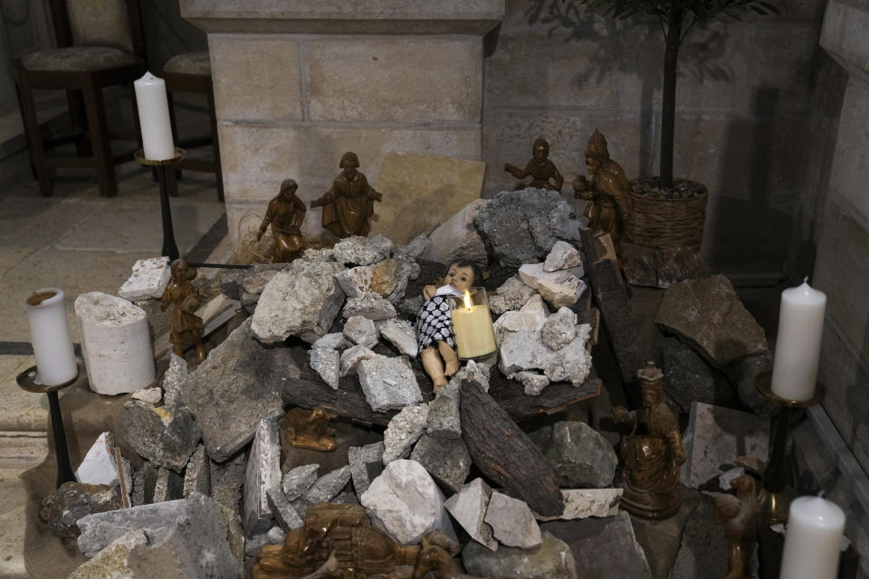 An installation of a scene of the Nativity of Christ with a figure symbolizing baby Jesus lying amid the rubble, in reference to Gaza, inside the Evangelical Lutheran Church in the West Bank town of Bethlehem, Sunday, Dec. 10, 2023. World-famous Christmas celebrations in Bethlehem have been put on hold due to the ongoing Israel-Hamas war. (AP Photo/Mahmoud Illean)