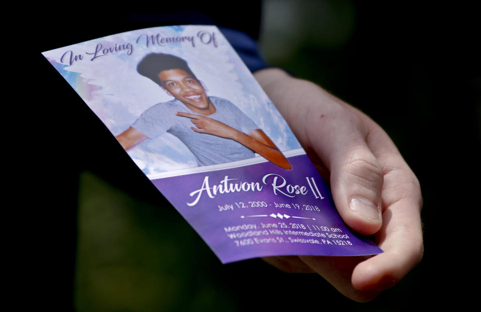 File-In this file photo from June 25, 2018, Kyle Fogarty shows a memorial card of Antwon Rose II after the funeral in Swissvale, Pa. Rose was fatally shot by a police officer seconds after he fled a traffic stop June 19, 2018 in the suburb of East Pittsburgh. The jury selection begins Tuesday in Harrisburg for the trial of former officer Michael Rosfeld, who is charged with criminal homicide. A judge ruled a jury from outside the Pittsburgh area is needed because of widespread publicity about the case. The jurors will be taken to Allegheny County for the trial next week. (AP Photo/Keith Srakocic, File)