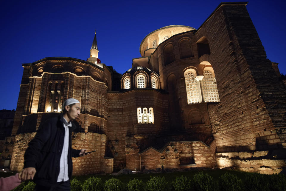 A Muslim cleric walks along a former Byzantine church which formally opened as a mosque, in Istanbul, Turkey, Monday, May 6, 2024. Turkish President Recep Tayyip Erdogan formally opened a former Byzantine church in Istanbul as a mosque on Monday, four years after his government had designated it a Muslim house of prayer, despite criticism from neighboring Greece. (AP Photo/Emrah Gurel)