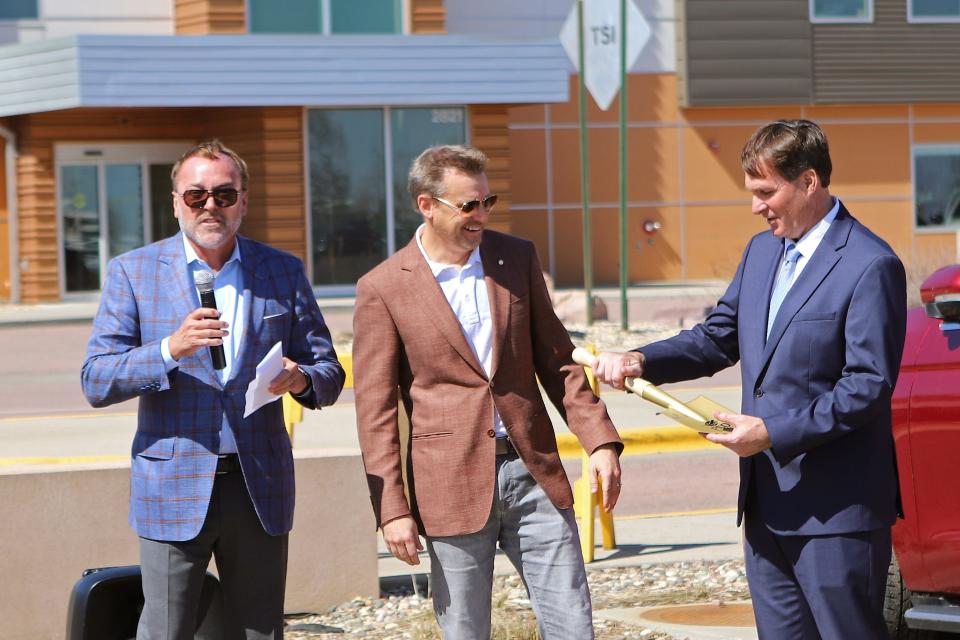 From left: Kent Cutler presents Lon Stroschein and Dan Letellier with a ceremonial gold shovel at the groundbreaking for the Sioux Falls Regional Airport parking ramp on Wednesday, April 12.