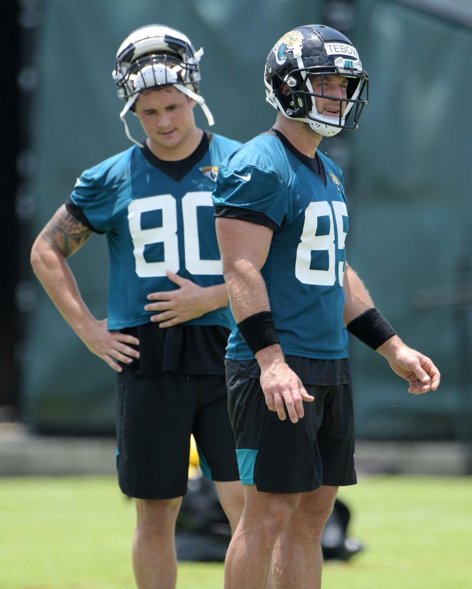 Jaguars (80) TE James O'Shaughnessy and (85) TE Tim Tebow on the field during a break between drills at Thursday's OTA session. (Bob Self/Florida Times-Union)